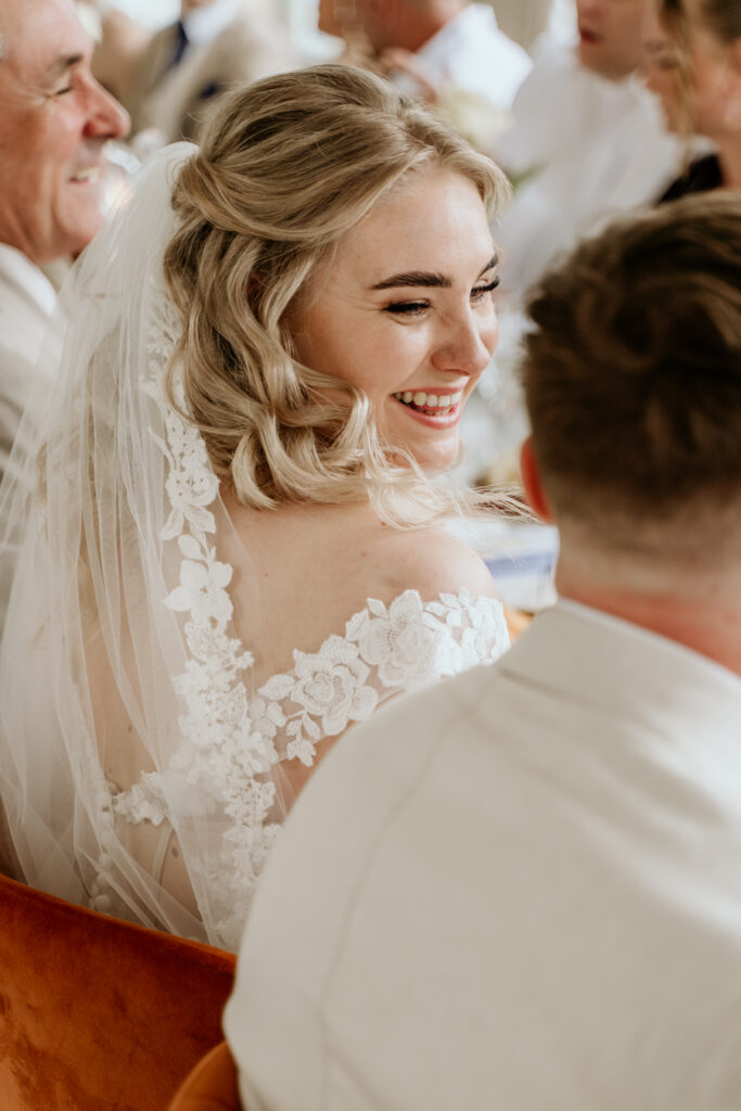 bruid lacht naar bruidegom aan tafel